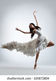 young beautiful dancer posing on a studio background