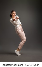 young and beautiful dancer posing in studio at colored background