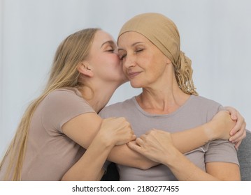 A young and beautiful daughter kiss her mother cancer patient and fortifies her to fight during the chemotherapy. Concept for love and support from beloved and family to breast cancer people - Shutterstock ID 2180277455