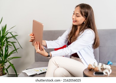 Young Beautiful Dietician Is Consulting Her Patient Online In Her Mobile Tablet.