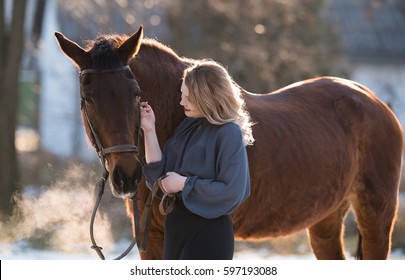 Young beautiful elegance modern woman posing with horse 