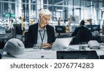 Young Beautiful Engineer Working and Managing Projects on Laptop Computer in an Office at Car Assembly Plant. Industrial Specialist Working on Vehicle Parts in Technological Development Facility.