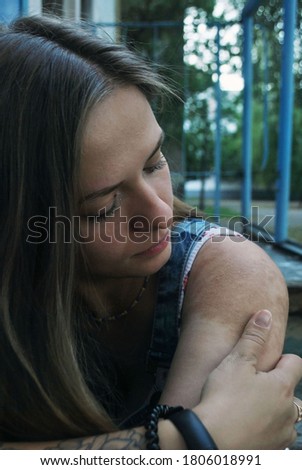 Young beautiful fair-haired woman with brown birthmark on the shoulder and the tattoo; skin features.