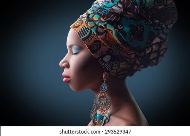 Young Beautiful Fashion Model With Traditional African Style With Scarf, Earrings And Makeup On Dark Blue Background.  
Developed From RAW, Edited With Special Care And Attention.