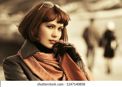 Young Beautiful Fashion Woman Walking On City Street Stylish Female Model With Bob Hair Wearing Black Leather Coat And Brown Scarf 