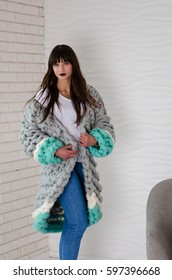 Young Beautiful Fashionable Woman Standing Near Chair In Merino Wool Jacket