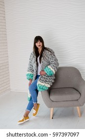 Young Beautiful Fashionable Woman Standing Near Chair In Merino Wool Jacket