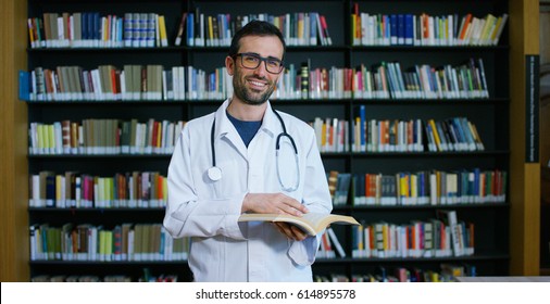 A young and beautiful female doctor in a library smiling happy and holding books after doing a search and after studying. Concept: educational, portrait, library, and medical care and welfare