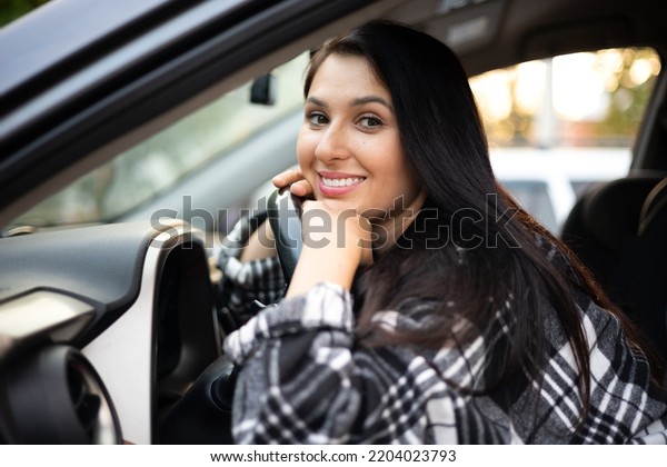 A young beautiful female driver sits behind the\
wheel of her car. A modern lady. A trip, a journey. Lifestyle. High\
quality photo