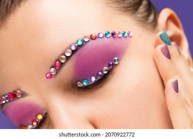 Young Beautiful Female With Gems Make Up. Glitter Jewelry Body Art On Female Model Face. Gems Decoration On Eyes Of Young Female