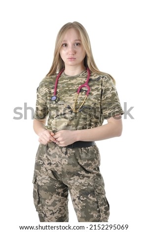Young beautiful female military doctor in a camouflage uniform with stethoscope around her neck looking at camera isolated on a white background