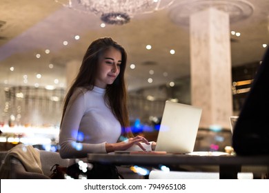 Young beautiful female student, write school paper or freelancer works on project at cafeteria or coworking hub, writes code for startup company, successful woman empowered and independent