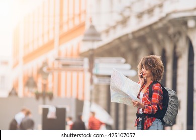 Young beautiful female traveler looking at the map
