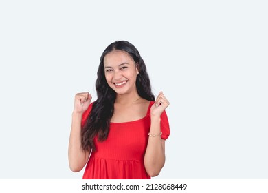 A young beautiful Filipina feeling pumped up and happy. Wearing a red dress.Claiming achievements in academics. Isolated in a white background - Shutterstock ID 2128068449