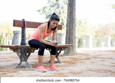 Young Beautiful And Fit Sport Woman Looking At Mobile Phone Internet App Tracking Performance After Running Workout Sitting On Park Bench Happy And Relaxed In Healthy Lifestyle Concept