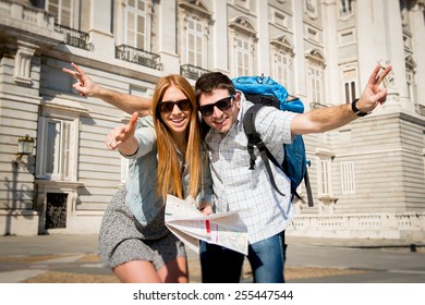 young beautiful friends tourist couple visiting Madrid - Spain on holidays exchange students posing together in town happy with city map on sunny day in travel and vacation concept