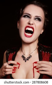 Young beautiful furious vintage woman with vampire fangs crying