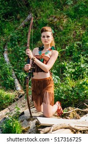 The young beautiful girl amazon aiming a bow while hunting in the forest, mythical character, a fairy tale, the legend