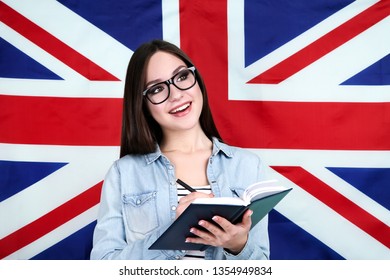 Young beautiful girl with black glasses and notepad on British flag background
