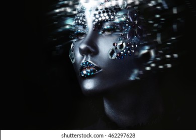 Young beautiful girl in black makeup with rhinestone, dark background, motion effect