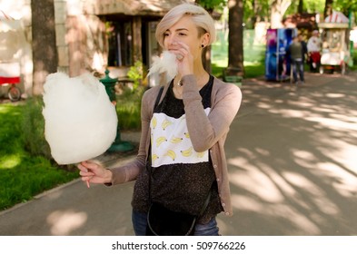Young beautiful girl with cotton candy in the park