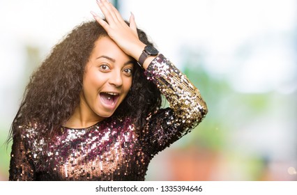 Young Beautiful Girl With Curly Hair Wearing Night Party Dress Surprised With Hand On Head For Mistake, Remember Error. Forgot, Bad Memory Concept.