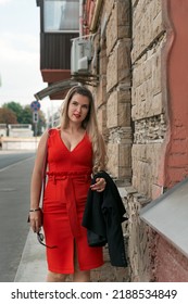 Young Beautiful Girl With Curvy Body Shape Walking On The Street. Red Sexy Fitting Sleeveless Dress