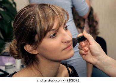 Young beautiful girl doing a major make-up brush