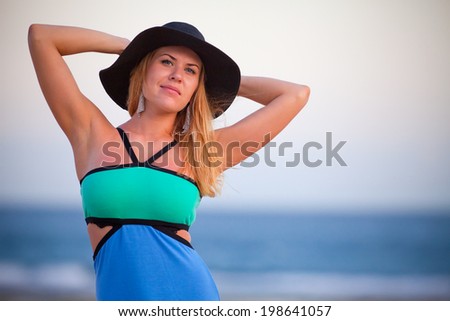 young beautiful girl with a hat of blue sea background