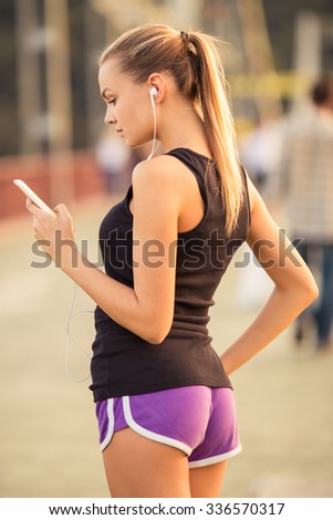 Similar – Woman with earphones listening music in smartphone