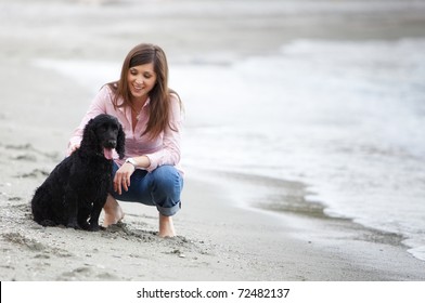 Young beautiful girl with her dog in the beach