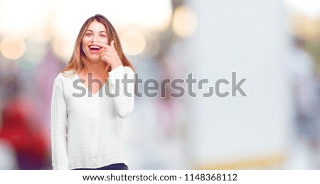 young beautiful girl joking, sticking tongue out with a funny, silly and playful expression, looking like a fool.