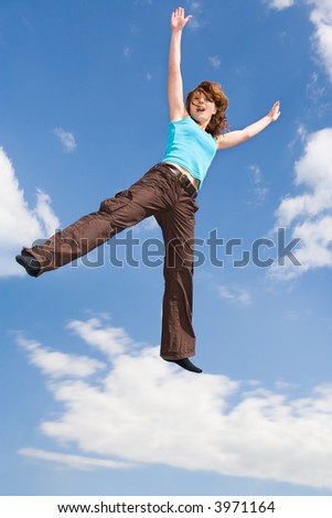 young, beautiful girl is jumping under the sky
