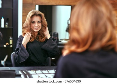 Young, Beautiful Girl Looking Into A Mirror In Beauty Salon