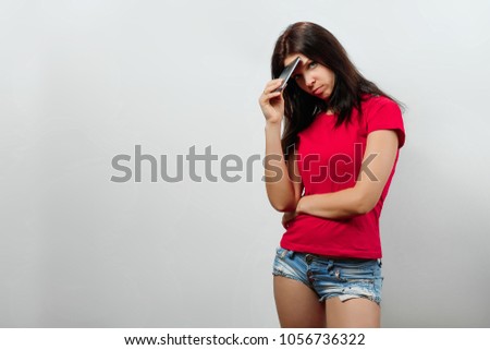 Young, beautiful girl is looking into the phone. Isolated on a light background. Different human emotions, feelings of facial expression, attitude, perception, body language, reaction.
