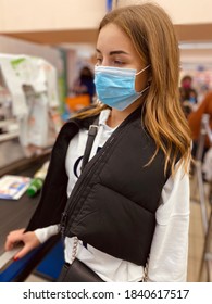 Young Beautiful Girl In Medical Mask Against Coronavirus At Checkout In Grocery Store. Covid-19. 