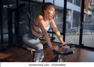 Young beautiful girl on an exercise bike in a gym. Cycling
 - Shutterstock ID 1533166856