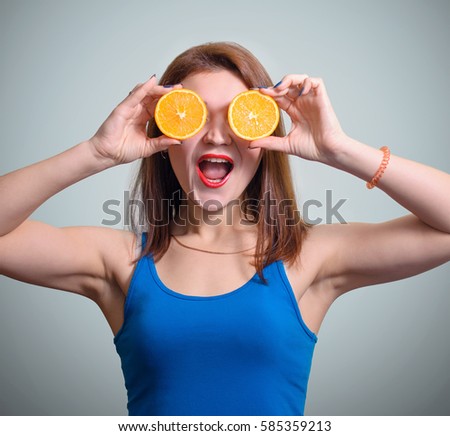 Young beautiful girl orange slices closes his eyes. Isolated on gray studio background