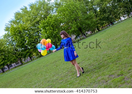 A young beautiful girl playing with balloons outdoors 