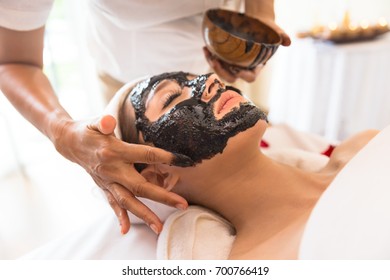 Young beautiful girl in rejuvenate skin mask for face relaxing in spa salon.
