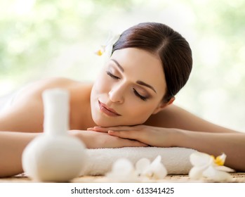 Young and beautiful girl relaxing in spa salon. Massage therapy over seasonal summer or spring background. Healing medicine and health care concept.  - Shutterstock ID 613341425