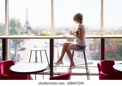 Young Beautiful Girl With Sitting Near The Panaramic Window In A Cafe In Paris. Eiffel Tower. Sunny Day In Restoran