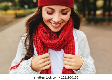 Young beautiful girl smiles laughing outdoors in a red hat and scarf gray cardigan sunset sun , energetic mixed race Caucasian young woman. - Powered by Shutterstock