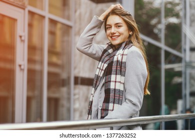 young and beautiful girl standing near building in a city