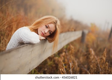 Young Beautiful Girl Standing On The Bridge Over The River. Redhead Or Blonde Romantic Waiting For A Man. Maybe Sad, Fashion Photography