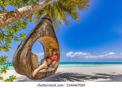 Young beautiful girl in swimsuit blonde hair relaxing in hammock luxury tropical beach amazing landscape. Outdoors vacation lifestyle portrait stunning young woman enjoying swing on tropical palm tree