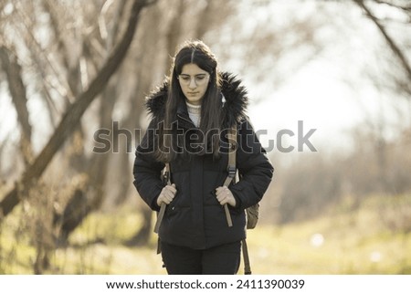Young and beautiful girl taking a nature walk in autumn