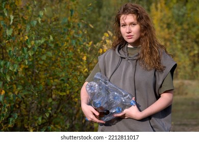 Young Beautiful Girl Volunteer, Woman Collecting Spilled Trash Garbage, Female Hand Cleaning Up Used Plastic Bottles In Forest Or Park. Ecology, Environmental Conservation, Pollution. Recycling Reduce