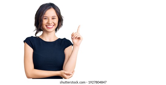 Young beautiful girl wearing casual clothes smiling happy pointing with hand and finger to the side 