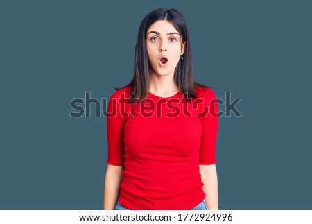 Young beautiful girl wearing casual t shirt scared and amazed with open mouth for surprise, disbelief face 